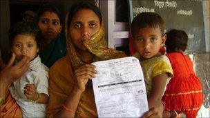 A woman in Bihar shows the document which entitles her daughter to state benefits