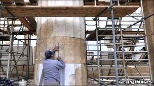 Man doing restoration work on a column of the acropolis