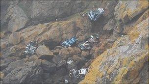 Vehicles at the bottom of the cliffs at Pleinmont