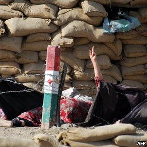 A wounded woman raises her hand next to a security checkpoint during exchange of fire with Pakistani troops in Quetta on 17 May 2011.