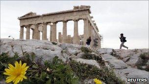 Boy runs past the Parthenon in Athens