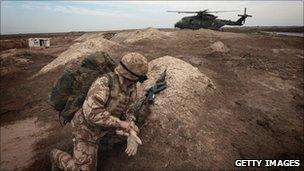 A British soldier watches as a helicopter arrives