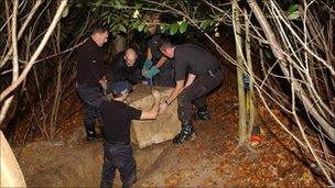 Police removing the box from the hole