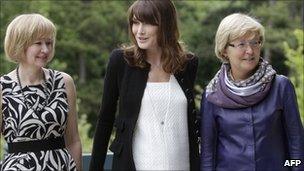 French President Nicolas Sarkozy's wife, Carla Bruni-Sarkozy (C) poses with Laureen Harper (L), wife of Canadian Prime Minister Stephen Harper and Geertrui Van Rompuy-Windels, wife of European Council President Herman Van Rompuy, prior to a working lunch at the Villa Strassburger on the sidelines of the G8 summit in Deauville, western France, on Thursday