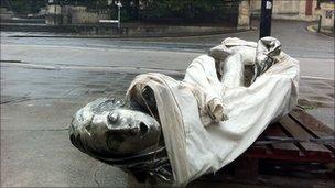 One of the three figures smashed on the pavement