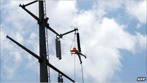 Employee of the Karachi Electric Supply Company (KESC) fixes a power line