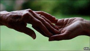 Elderly hand touching a younger hand