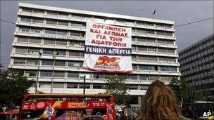 Protesters hung a banner from the Greek finance ministry calling for a general strike