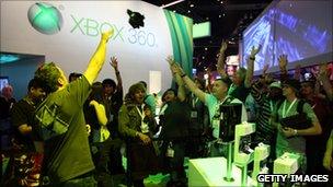 Individuals waving their hands inside the Xbox booth at the 2010 E3 Expo