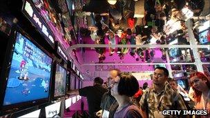 Individuals crowded around a game at the E3 Expo in 2011