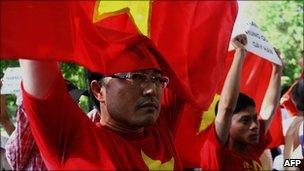 Protesters hold Vietnamese flags and anti-China banners during a protest in Hanoi