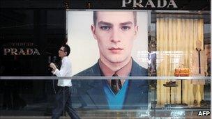 A man walks past a Prada store in Hong Kong