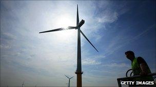 A maintenance worker by a offshore wind turbine