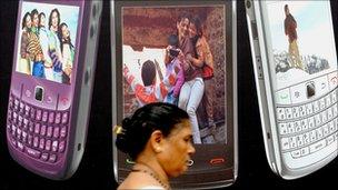 Mumbai woman walks past billboard for mobile phones