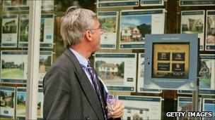 Man looking in estate agents window