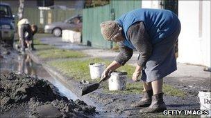 Elizabeth Parsons,73, of Shirley cleans up liquefaction, the day after two magnitude 6.0 and 5.5 earthquakes struck the region on June 14, 2011