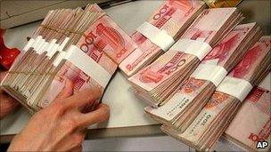 A teller counts Chinese yuan notes