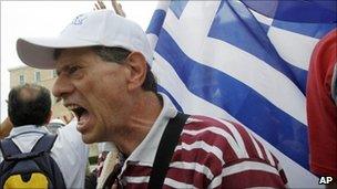 Demonstrator shouts slogans outside the parliament in central Athens