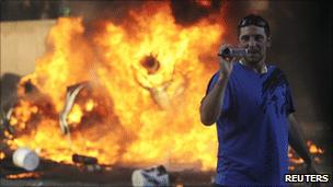 A man holds a video camera during the riot in Vancouver