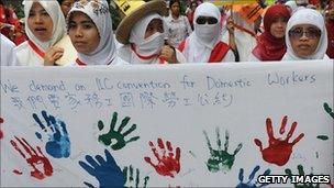 Domestic workers holding a banner demanding more rights