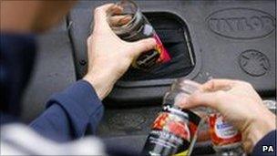 Man putting glasses into a recycling container