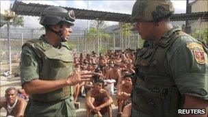 A National Guard general, Antonio Benavidez (left), near sitting inmates in the El Rodeo jail (17 June 2011)