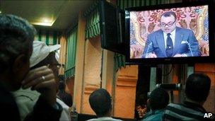 Moroccan customers watch a live broadcast from Rabat of a speech by Morocco's King Mohammed VI at a cafe in Casablanca, on 17 June 2011