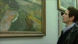 Paul McGann looking at an Albert Richards paintings