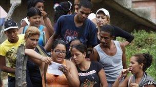 A relative of an inmate reads a list of prisoners who survived outside El Rodeo I prison in Guatire, Venezuela, Monday, 20 June 20