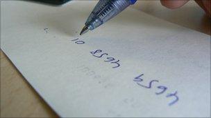 Cheque guarantee number being written on the back of a cheque