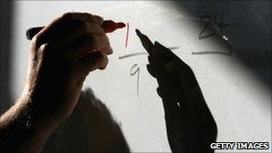 Hand writing fraction on blackboard