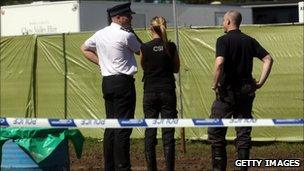 Police officers and crime scene investigators attend the scene