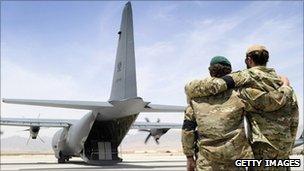 Two special forces soldiers embrace as the C-130 carrying Sergeant Brett Wood, departs Tarin Kot Airfield, Saturday, May 28, 2011, in Uruzgan, Afghanistan