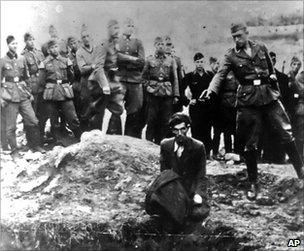 A Nazi soldier prepares to shoot a Jewish man at the side of a mass grave near Vinnitsa (undated image)