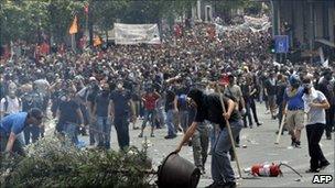 Demonstrators walk among debris