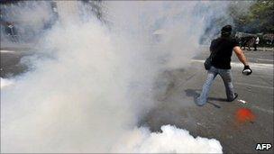Protesters walk among teargas