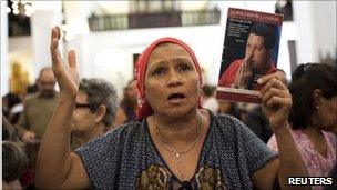 A woman attends Mass to pray for Hugo Chavez to make a speedy recovery