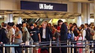 Passengers wait to go through passport control at Heathrow Airport