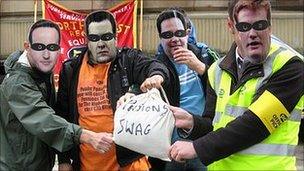 Protesters wearing David Cameron, George Osborne, Nick Clegg and Danny Alexander masks clutch a bag marked "pensions swag" in Lancashire