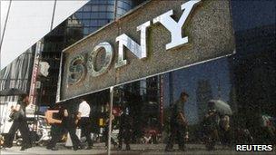 Pedestrians walk past a Sony sign in Tokyo