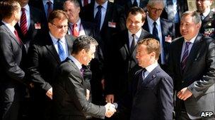 Russian President Dmitry Medvedev (bottom R) and NATO chief Anders Fogh Rasmussen (L) shake hands as they pose for a photo with the participants in the Russia-Nato Council in the Black Sea resort of Sochi, on Monday