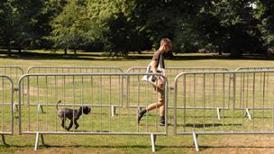 A man walks his dog past barriers