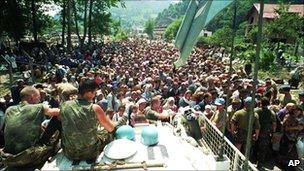 File picture dated 13 July 1995 showing Dutch UN peacekeepers sitting on top of an APC while Muslim refugees from Srebrenica, eastern Bosnia, gather in the village of Potocari, some 5km north of Srebrenica