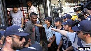 Emmanuel Emenike, Fenerbahce striker, is surrounded by policemen as he arrives at court in Istanbul on 6 July