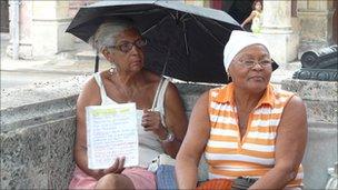 Two women on a street where people gather to try to swap apartments