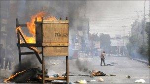 Pakistani protesters burn material in the middle of a street in a violence-hit western neighbourhood of Karachi on 8 July 2011