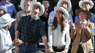 Prince William and his wife Catherine, Duchess of Cambridge, push a plunger to officially start the Stampede parade in Calgary