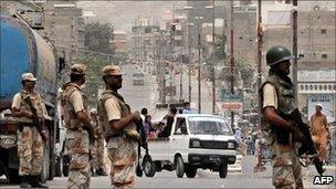 Pakistani paramilitary soldiers stand guard as residents are driven out of Karachi, 9 July 2011