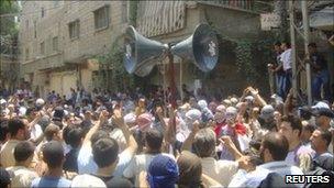 Anti-government demonstrators march through the streets after Friday prayers in Hajar al-Asswad in Damascus - 8 July 2011