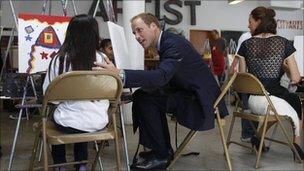 Prince William and his wife, Kate, Duchess of Cambridge, painting pictures with a child